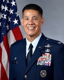 Col. Jason H. Parker, 628th Air Base Wing and Joint Base Charleston commander in Air Force Dress Blues in front of a U.S. flag.