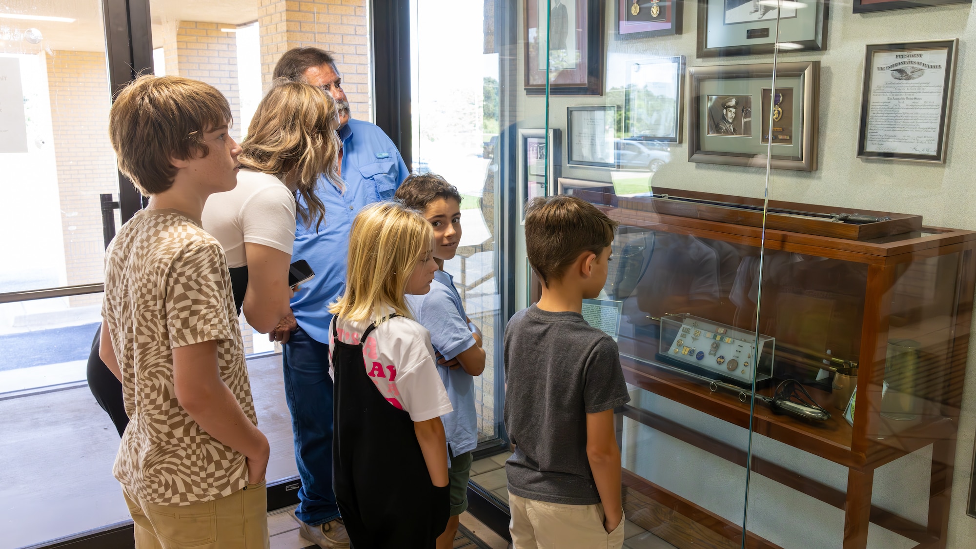 Phil Tinker and family look at display case