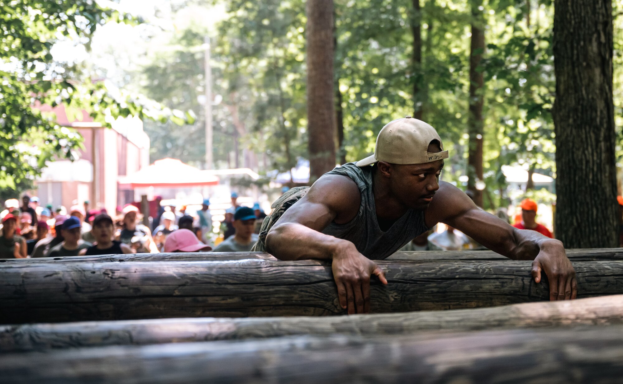 A cadet pulls himself across a log in an obstacle course