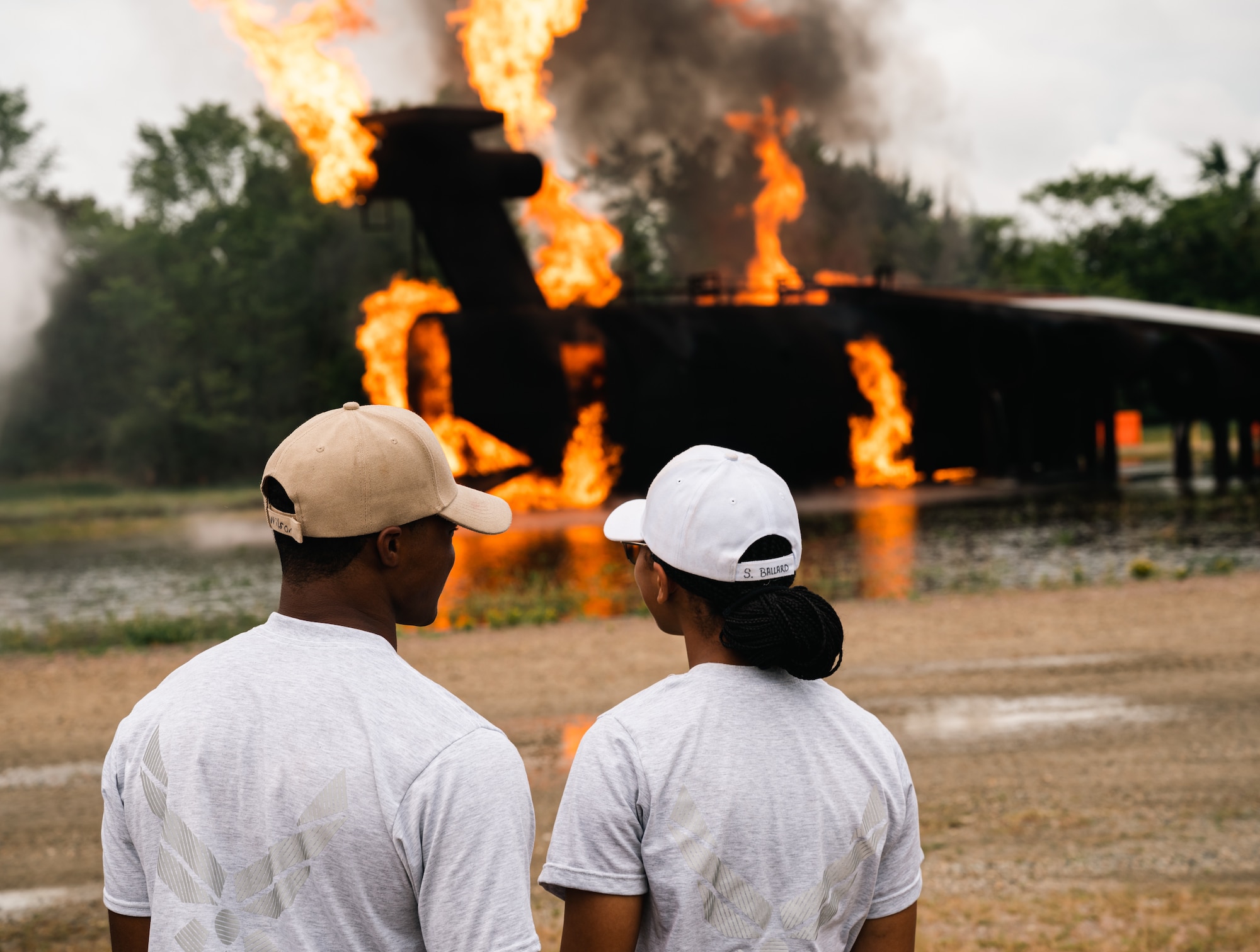 Two cadets watch a fire burn