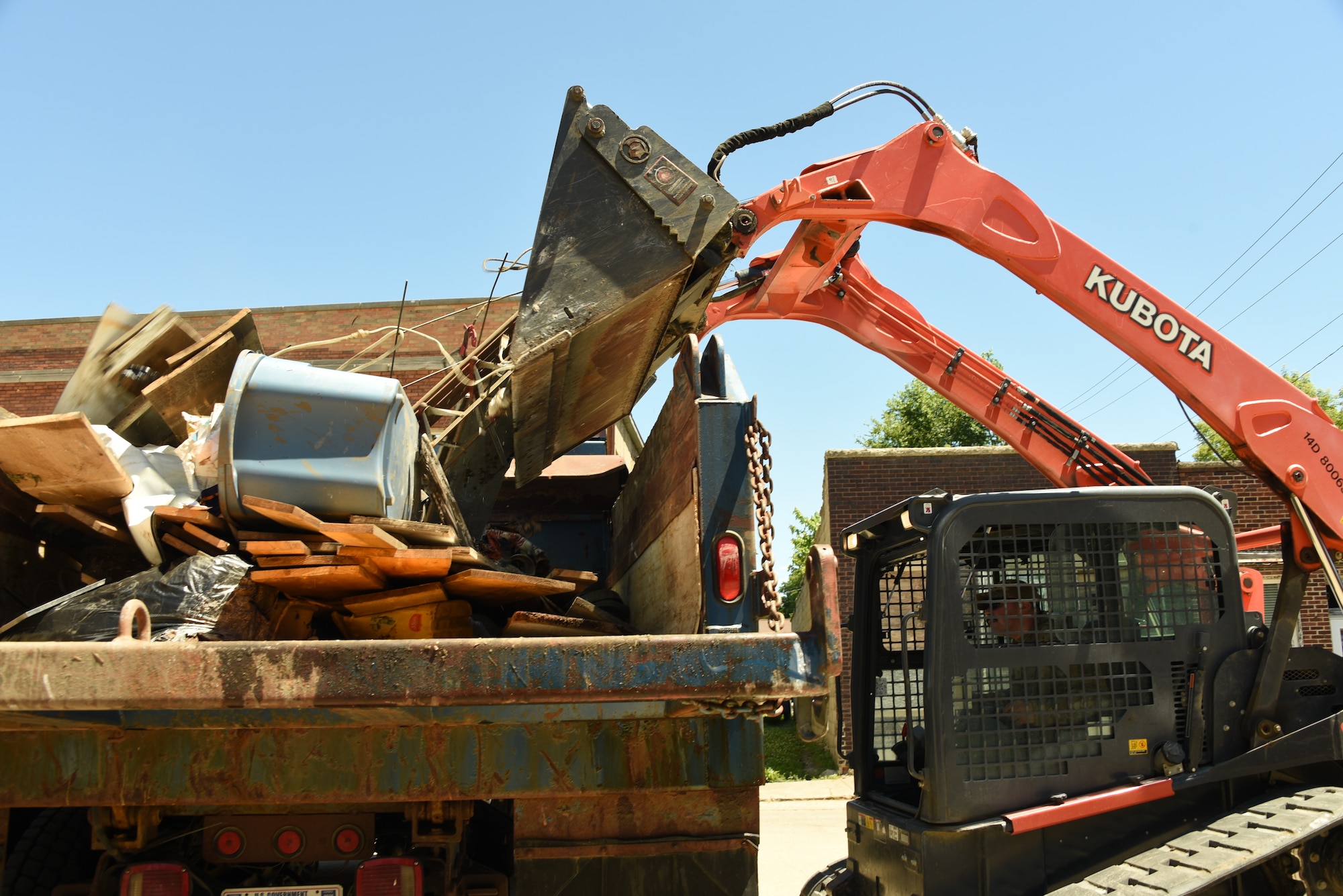 U.S. Air National Guard Staff Sgt. Seth Stamm, a 185th Air Refueling Wing Civil Engineering Squadron Power Production specialist, dumps debris in a dump truck