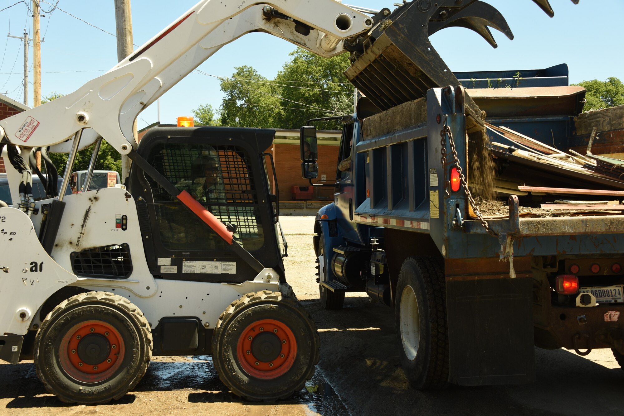 Staff. Sgt. Derrick Colyer, 185th Air Refueling Wing Heating, Ventilation, Air Conditioning and Refrigeration specialist, dumps debris in a dump truck