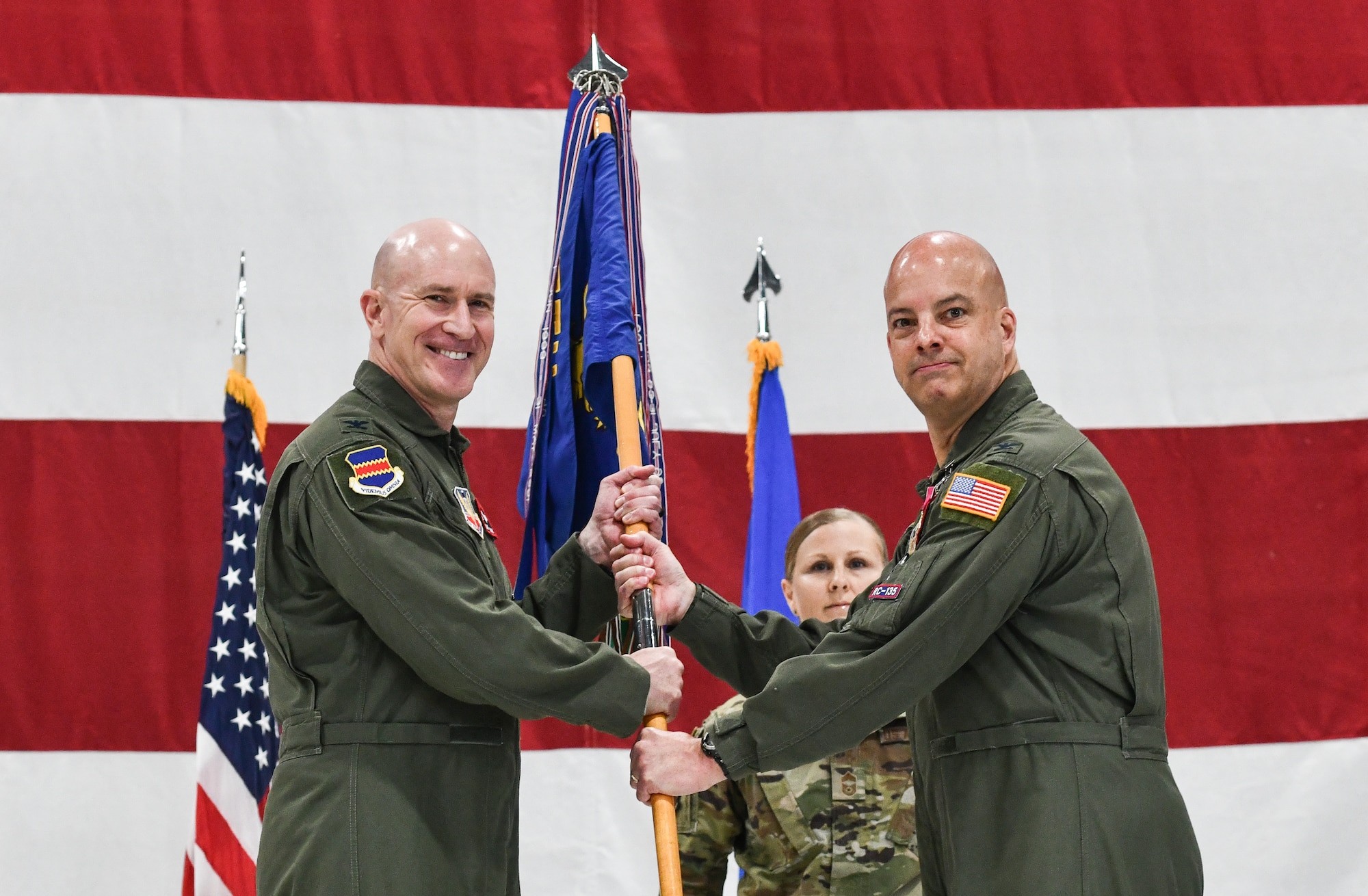 2 colonels hold a guidon