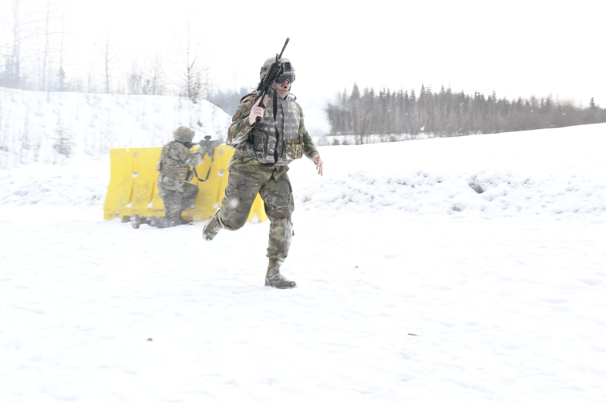 Senior Airman Caleb Forster, an aircraft structural maintenance technician in the 168th Maintenance Group, practices moving toward a simulated enemy while using cover, communicating with her team, and putting accurate fire down range as part of a multi-capable Airmen Shoot, Move, Communicate exercise
