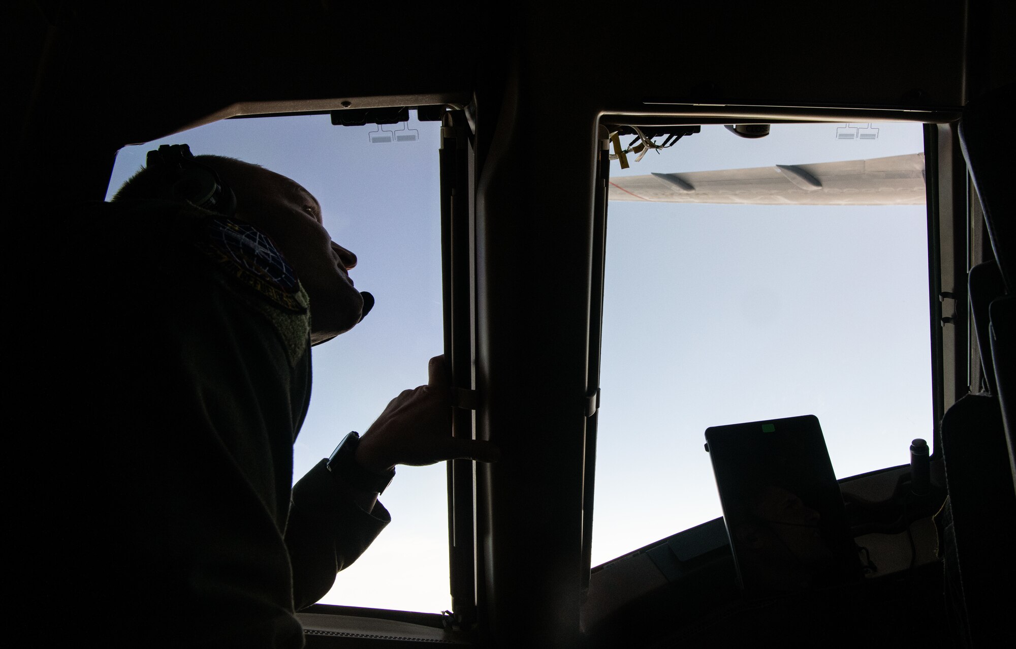 An Airman assigned to the 22nd Air Refeuling Wing looks out the window of a KC-46A Pegasus from McConnell Air Force Base, Kansas, that is participating in a Maximum Endurance Flight around the globe called Project Magellan June 29, 2024. Magellan was the world’s first nonstop, KC-46 westbound circumnavigation endurance flight that took off from McConnell June 29 and landed again July 1. (Courtesy Photo)
