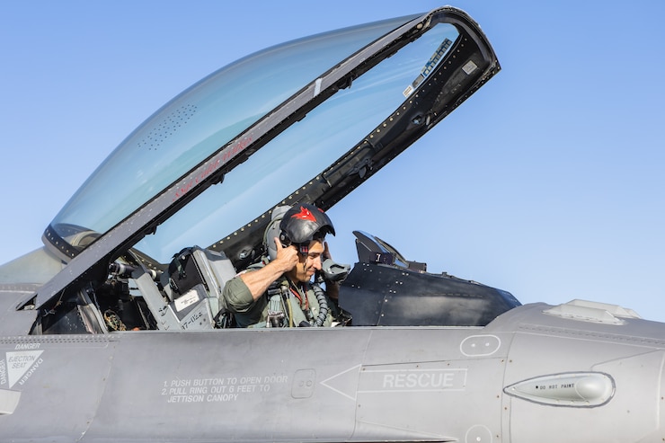 U.S. Air Force Lt. Col. Robert W. Pneuman, 119th Fighter Squadron F-16 pilot, 177th Fighter Wing, New Jersey Air National Guard, puts on his helmet inside of an F-16 Fighting Falcon fighter jet prior to a launch from Joint Base Pearl Harbor-Hickam, Hawaii, June 5, 2024.