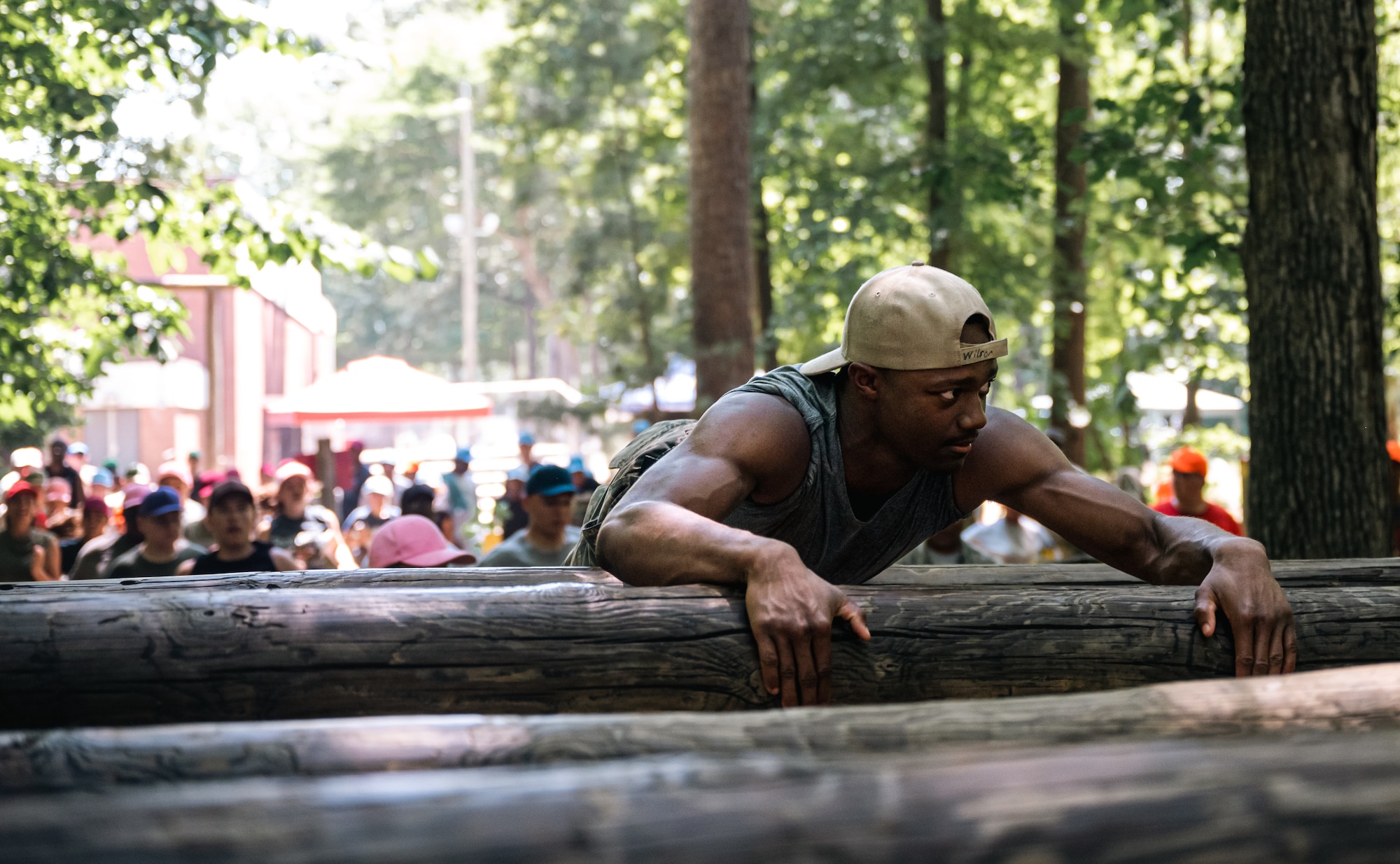 A cadet pulls himself across a log in an obstacle course