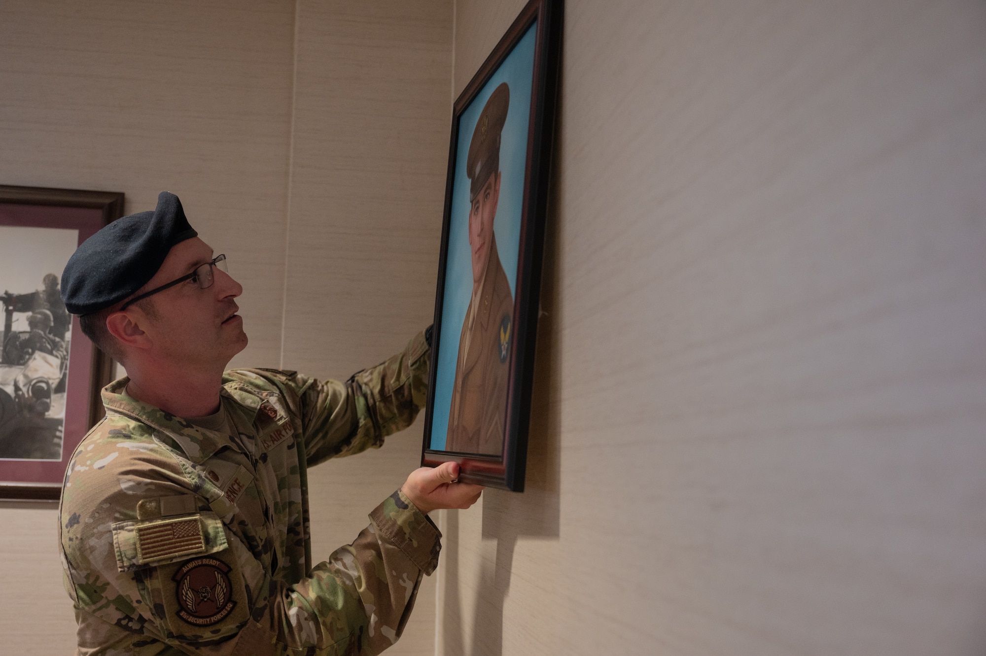 U.S. Air Force Lt. Col. Nicholas Brence, 51st Security Forces Squadron commander, hangs a portrait of Corporal Joseph Morin at Osan Air Base, Republic of Korea, June 27, 2024. Morin was killed in action on Nov. 1, 1950 while assigned to the 6149th Air Police Squadron, K-2, Taegu Air Base, ROK. (U.S. Air Force photo Staff Sgt. Christopher Tam)