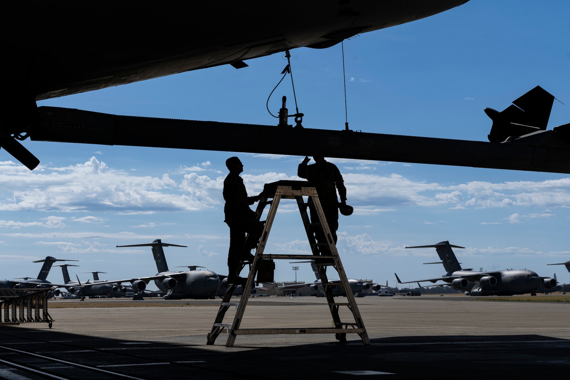 Two Airmen check the boom of a KC-10 Extender