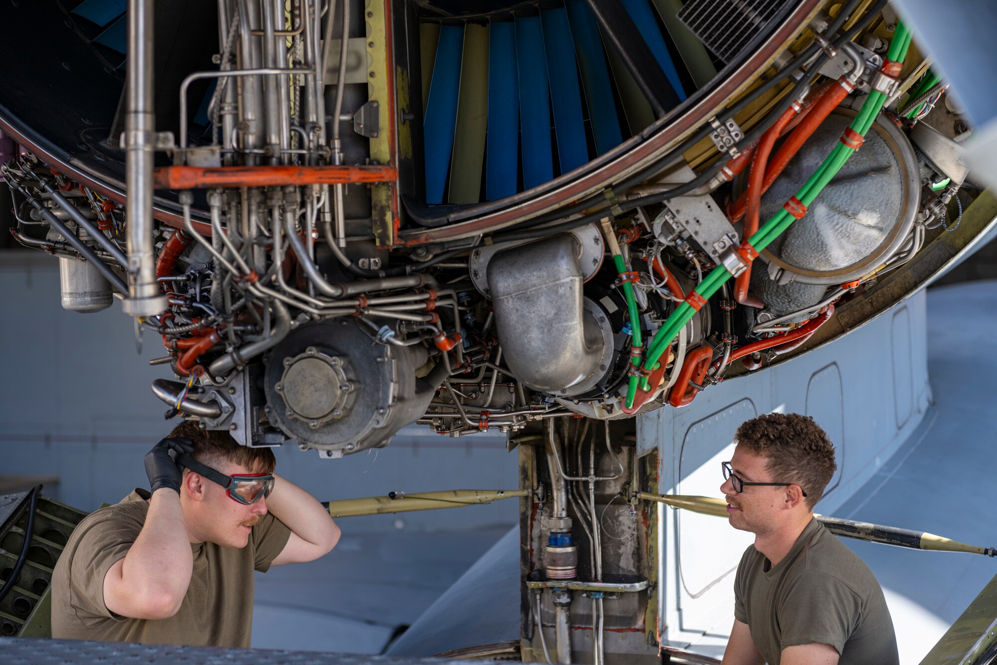 Two Airmen check the jet engine of a KC-10 Extender