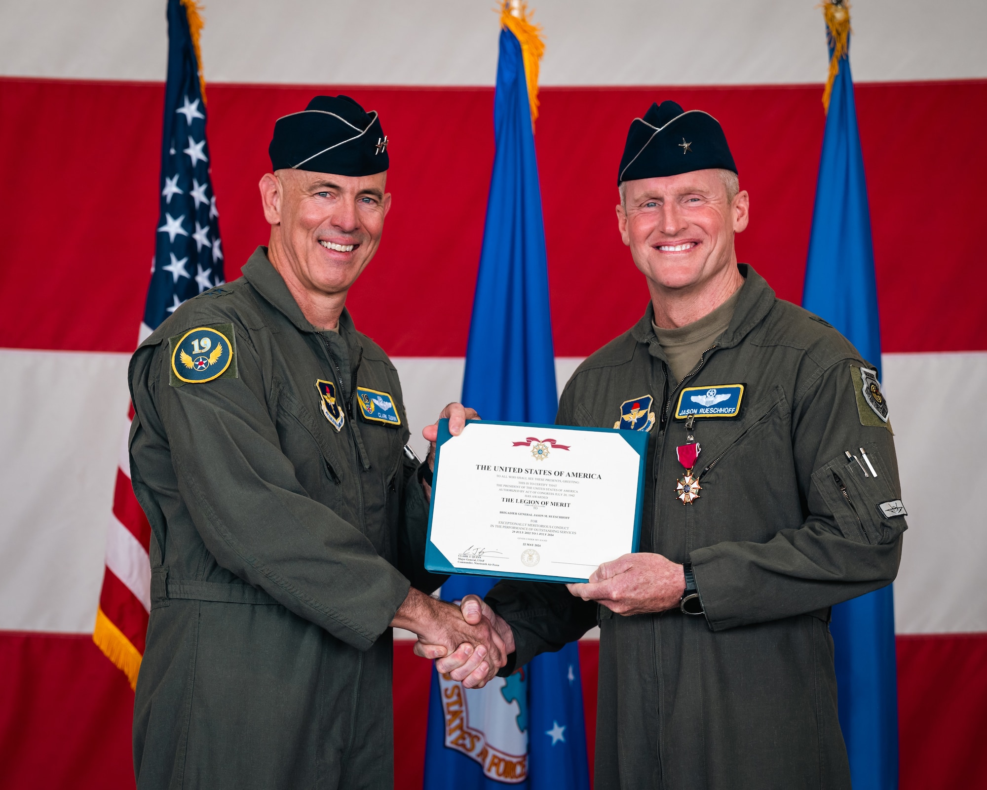 U.S. Air Force Maj. Gen. Clark J. Quinn (left), 19th Air Force commander, gives the Legion of Merit award to Brig. Gen. Jason Rueschhoff (right), 56th Fighter Wing outgoing commander, at the 56th FW Change of Command ceremony, July 1, 2024, at Luke Air Force Base, Arizona.
