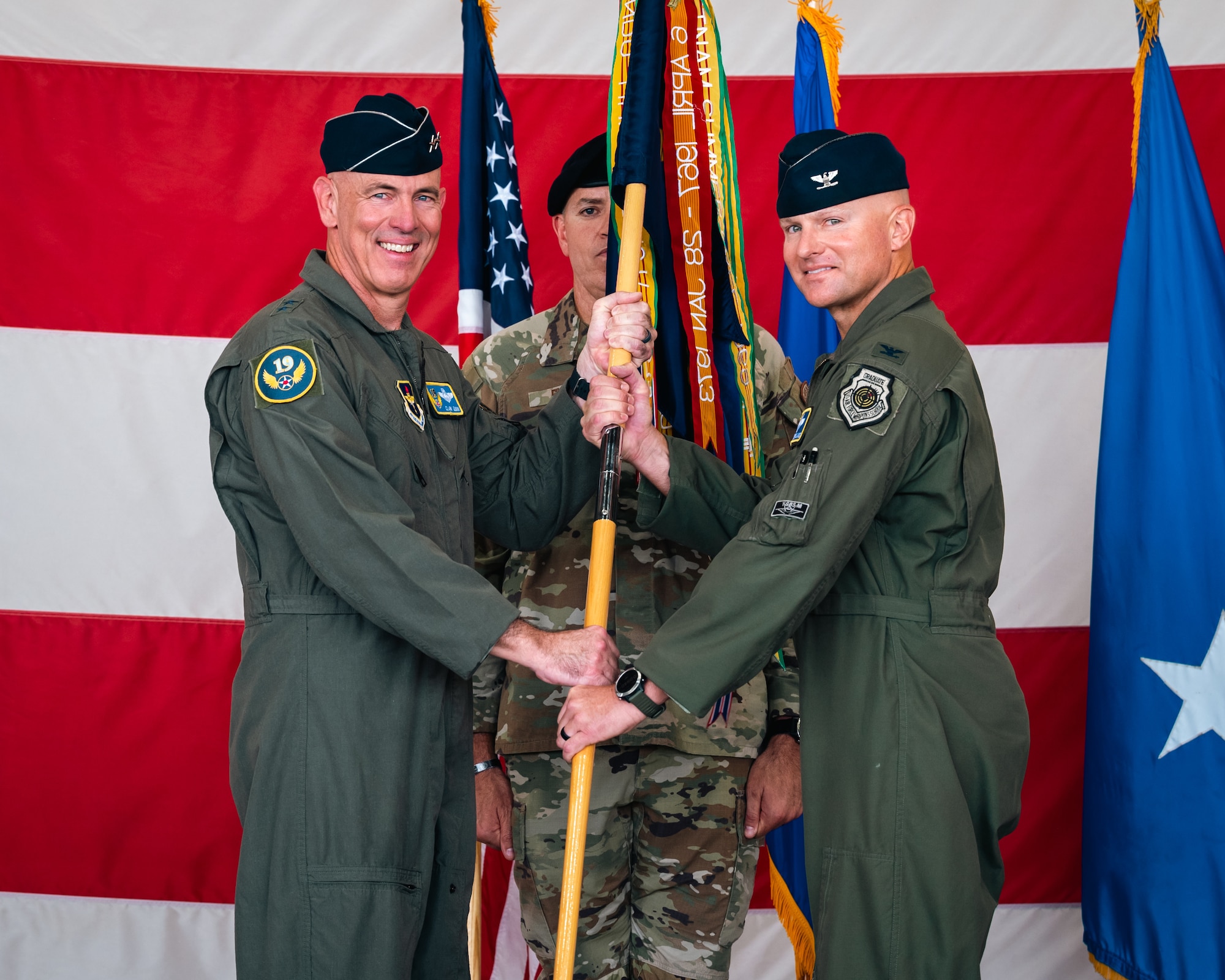 U.S. Air Force Maj. Gen. Clark J. Quinn (left), 19th Air Force commander, passes a guidon to Col. David Berkland (right), 56th Fighter Wing incoming commander, transferring command of the 56th FW from Brig. Gen. Jason Rueschhoff during the 56th FW Change of Command ceremony, July 1, 2024, at Luke Air Force Base, Arizona.
