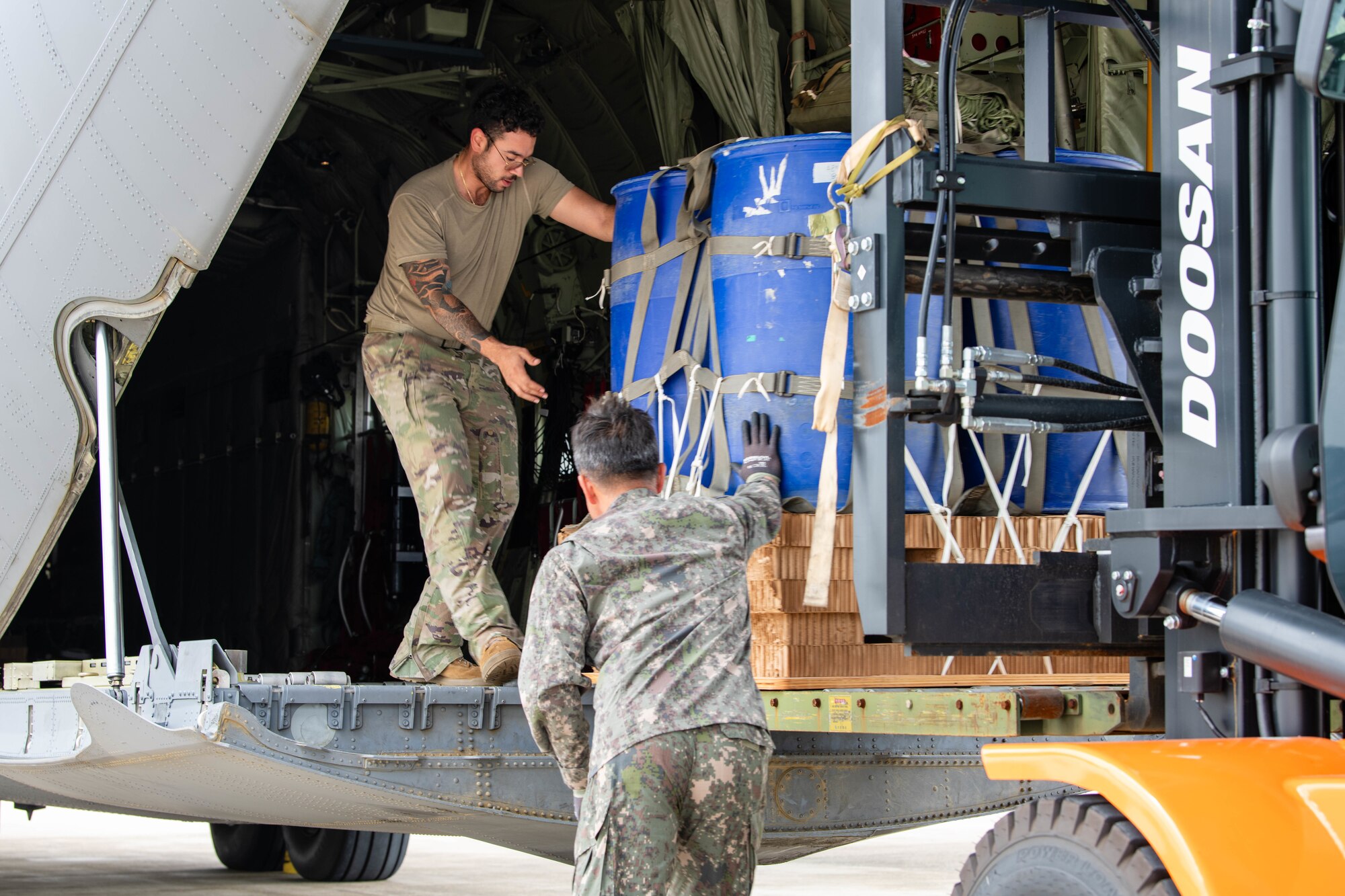 U.S. Air Force Senior Airman Cameron Palmer, 36th Airlift Squadron loadmaster, and a member of the Republic of Korea Air Force load container delivery system bundles onto a C-130J Super Hercules assigned to the 36th AS in preparation for an airdrop training event at Gimhae Air Base, Republic of Korea.