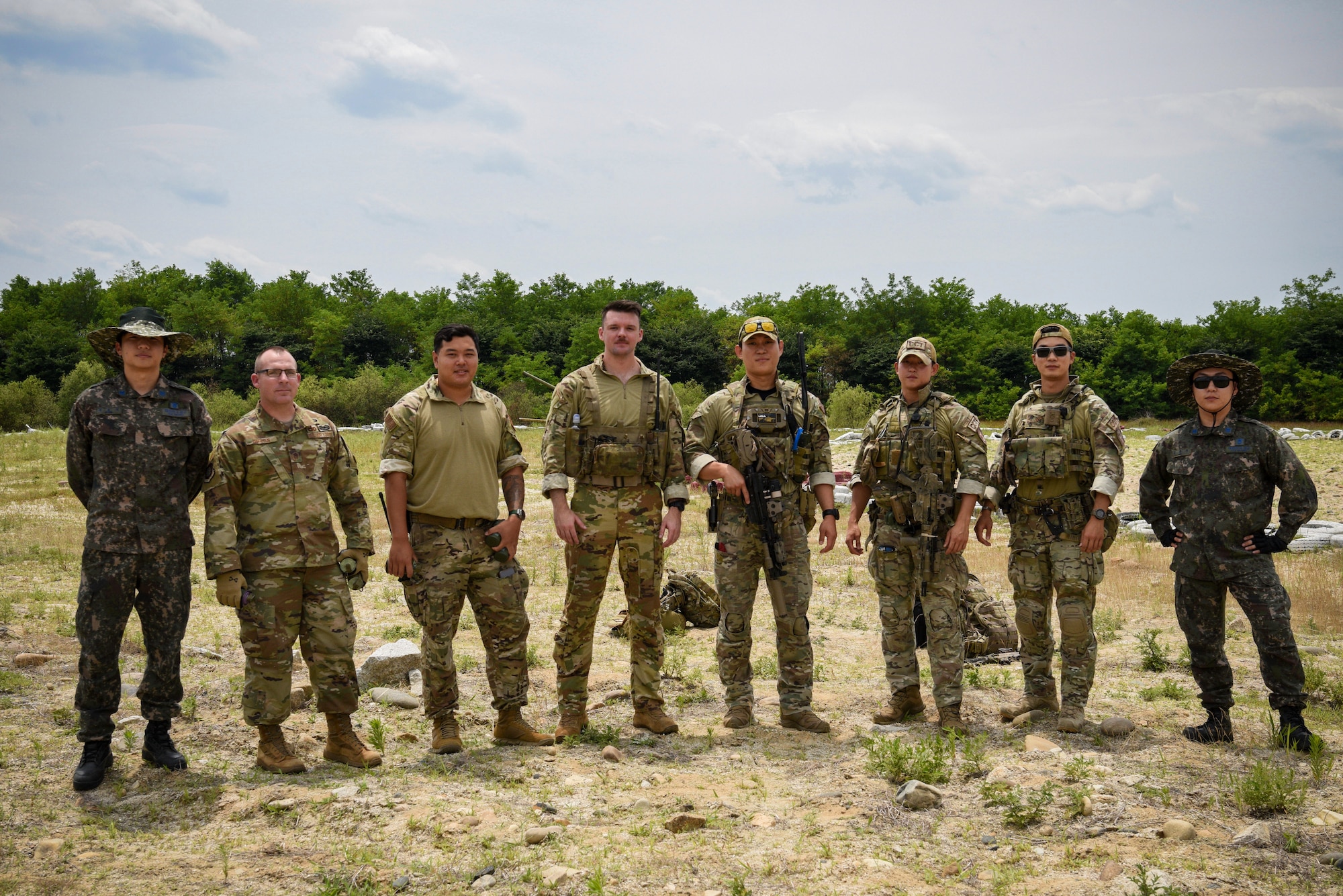 Members from the 607th Air Support Operations Group, Republic of Korea combat controllers, and Republic of Korea Air Force personnel pose for a photo while setting up for a combined ROK and U.S. cargo drop training event near Yeoju, Republic of Korea.