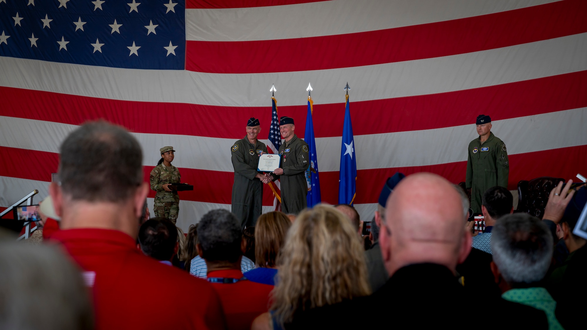 U.S. Air Force Maj. Gen. Clark J. Quinn (center left), 19th Air Force commander, awards the Legion of Merit to Brig. Gen. Jason Rueschhoff (center right), 56th Fighter Wing outgoing commander, before transferring command of the 56th FW to Col. David Berkland at the 56th FW Change of Command ceremony, July 1, 2024, at Luke Air Force Base, Arizona.