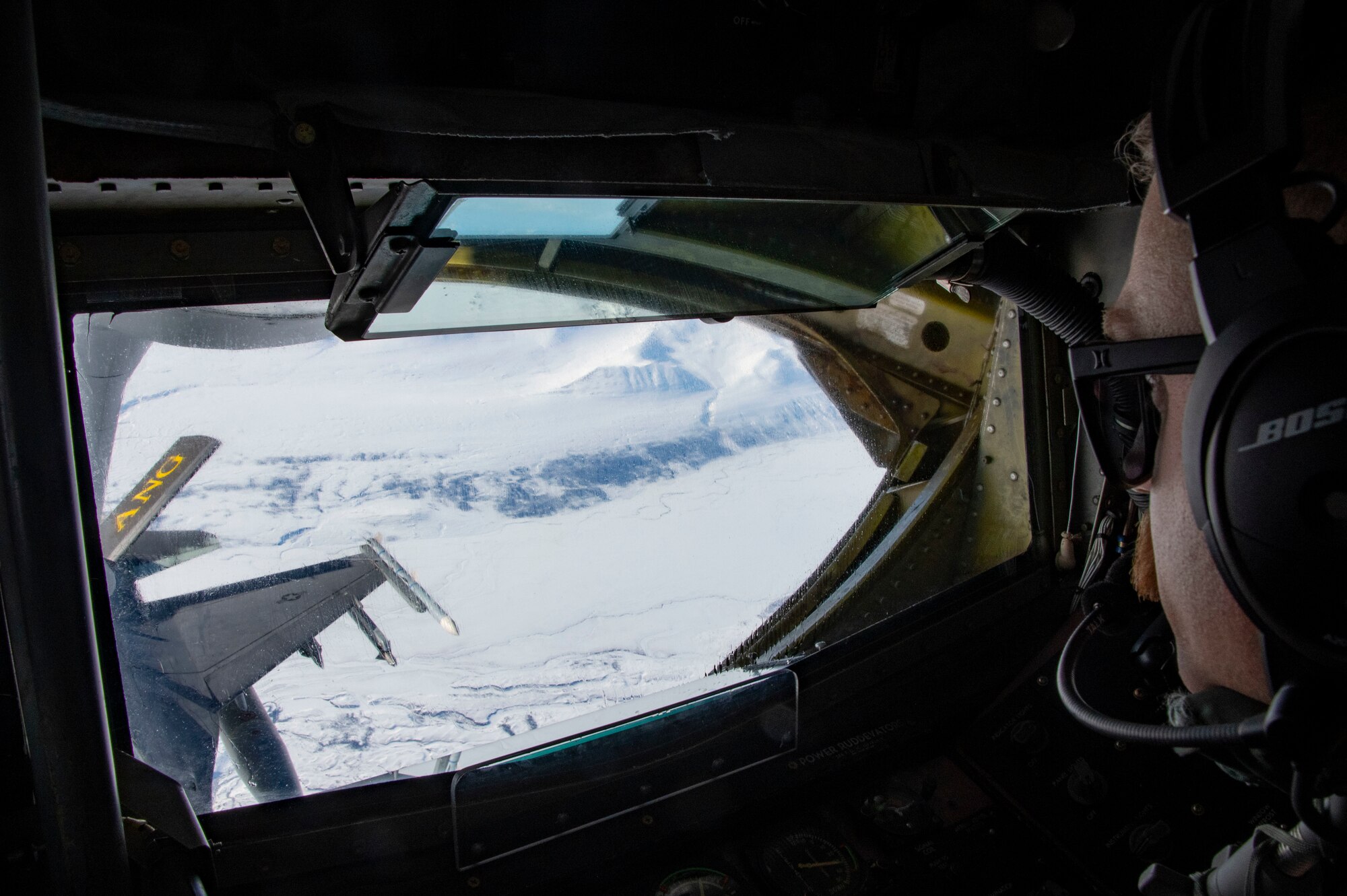 U.S. Air Force Senior Airman Scott Hurn, Alaska Air National Guard KC-135 Stratotanker boom operator, conducts aerial refueling operations for an F-16 Falcon.