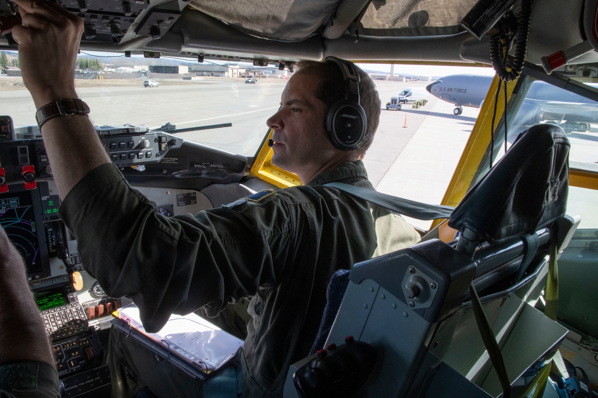 U.S. Air Force Capt. Jesse Sikora, a pilot with the 168th Wing, Alaska Air National Guard, talks over the radio and operates a KC-135 Stratotanker.