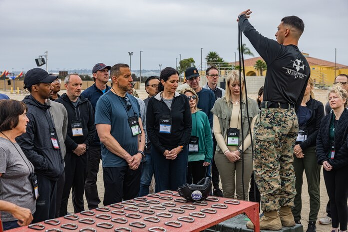 U.S. Marine Corps Staff Sgt. Isaac Castillo, a helicopter rope suspension technique master with Support Battalion, Recruit Training Regiment, provides a demonstration of the techniques required to complete the rappel tower to participants of the Joint Civilian Orientation Conference at Marine Corps Recruit Depot San Diego, California, June 28, 2024. JCOC is the DoD’s oldest and most prestigious public liaison program established in 1948. This program enables American business and community leaders to have a full immersive experience with their military. Participants of JCOC visited MCRD San Diego to observe recruit training and gain a better understanding about the transformation from recruits to United States Marines. (U.S. Marine Corps photo by Sgt. Jesse K. Carter-Powell)