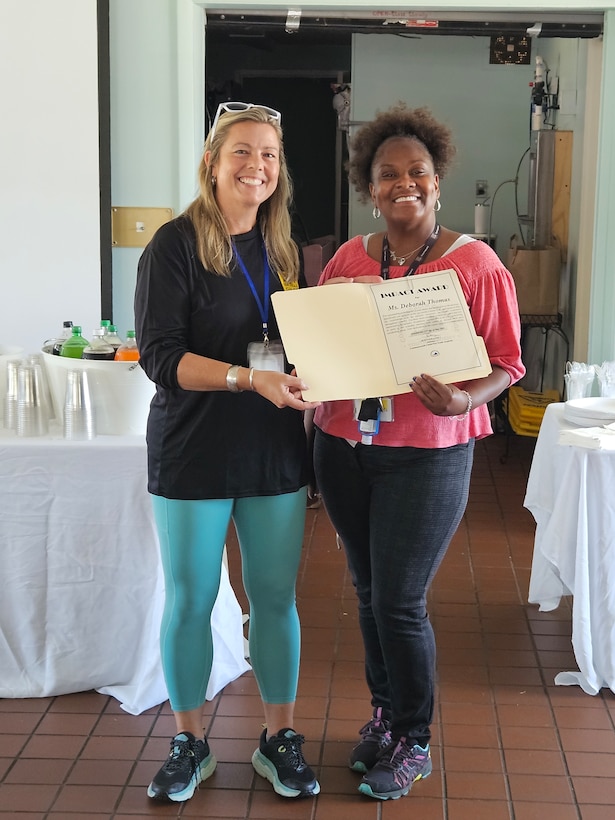 Jen Lanz, director of the Virginia Commonwealth ChalleNGe Youth Academy, presents an award to Deborah Thomas during an informal awards ceremony May 30, 2024, at the State Military Reservation in Virginia Beach, Virginia. Commonwealth ChalleNGe has been conducting training, seminars and numerous other activities during a three month pause in classes. The staff is now preparing for the 135 cadets of Class 61 to hit the ground July 16, 2024, at the State Military Reservation in Virginia Beach.