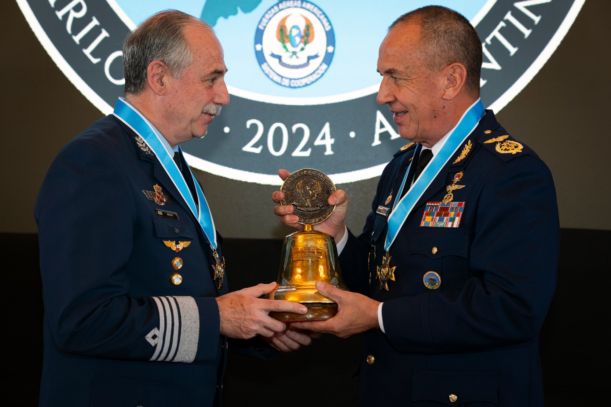 Argentinian Air Force Chief of Staff Gen. Fernando Luis Mengo, left, passes a ceremonial bell to Paraguayan Air Force Commander, Gen. Julio Rubén Fullaondo Céspede, right, during the 64th Conference of the American Air Chiefs meeting in San Carlos de Bariloche, Argentina, June 20, 2024. The transfer identifies where the next CONJEFAMER will be held and symbolizes the beginning of next year’s activities.