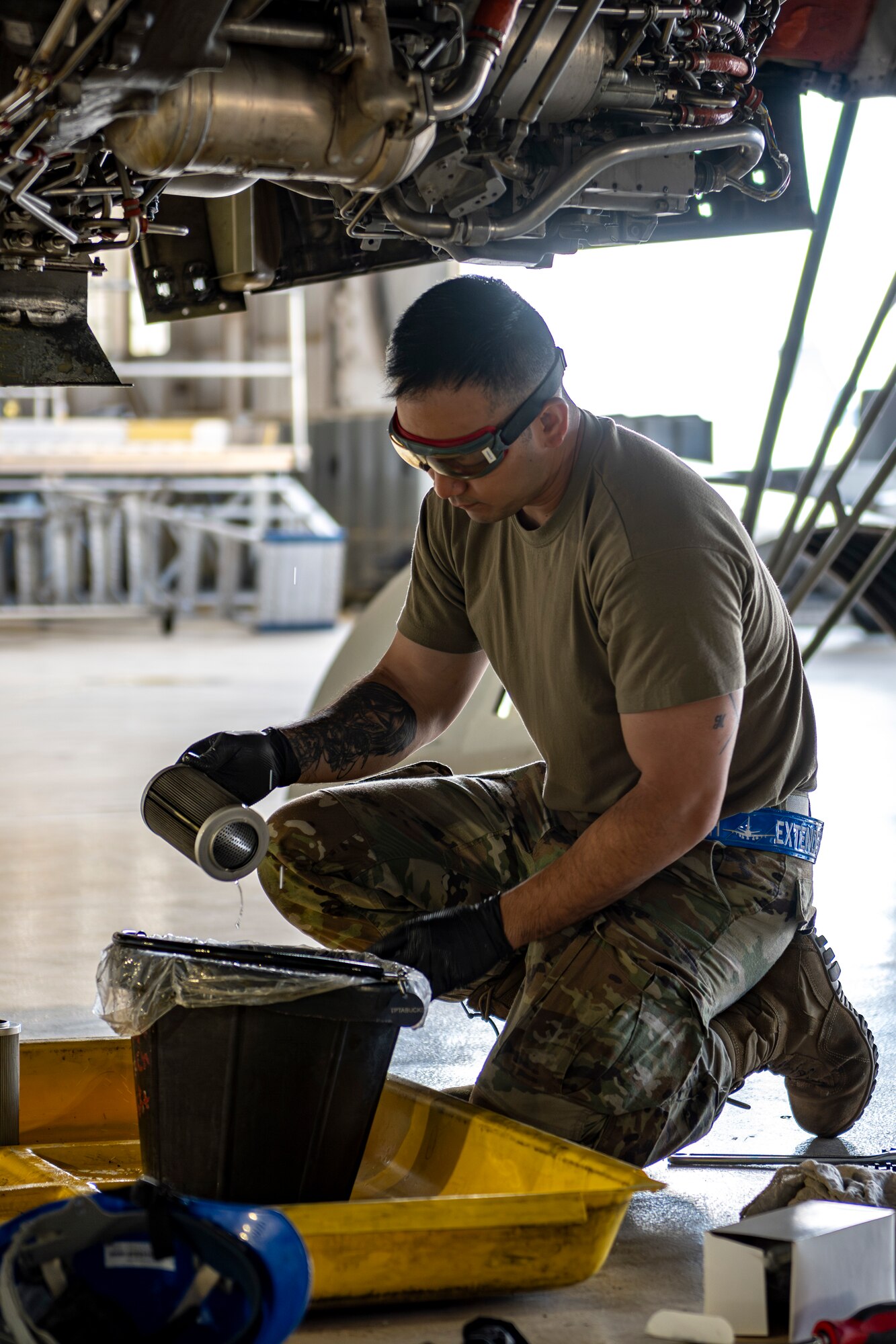 man checks oil filter on plane engine
