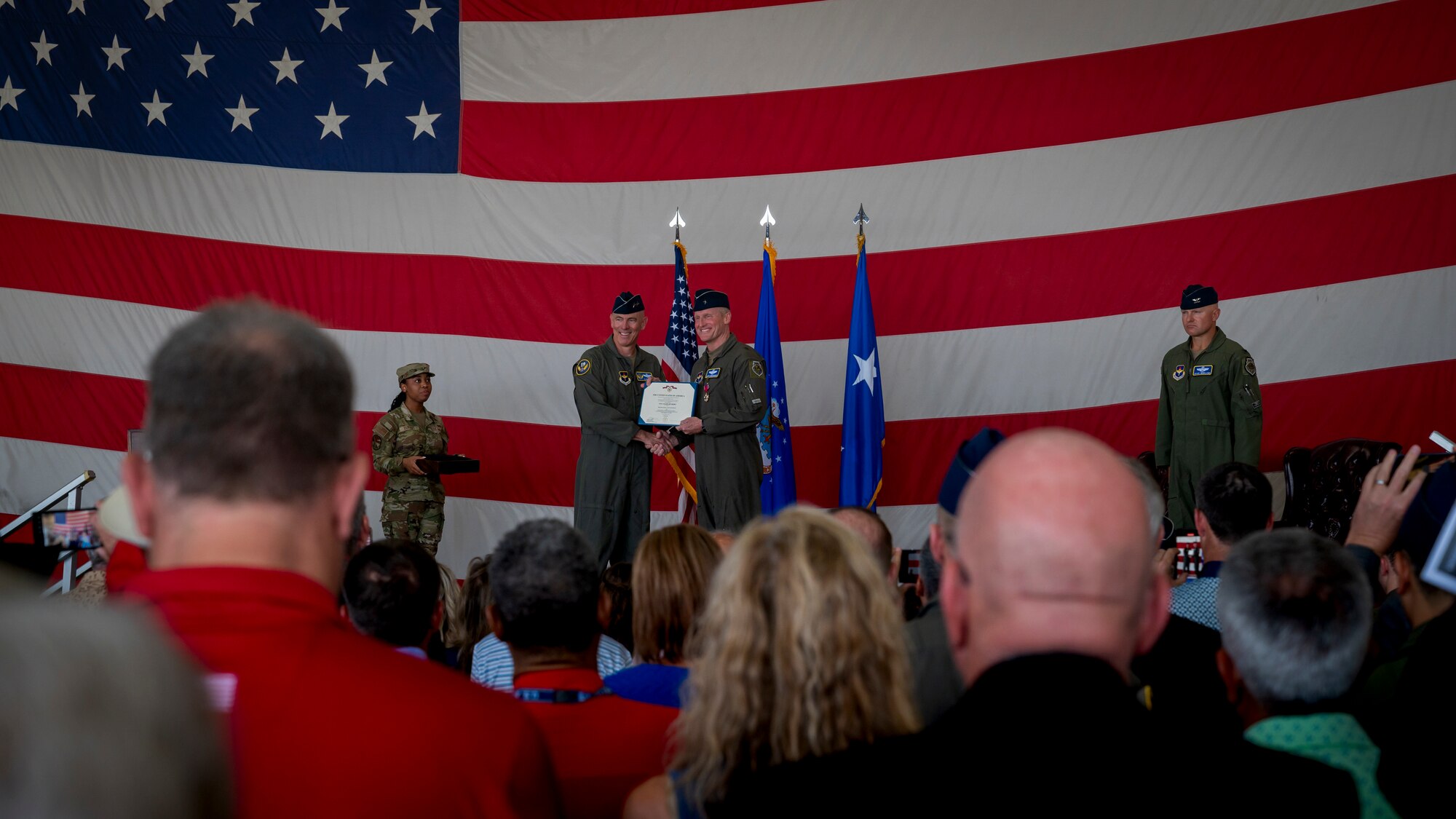 U.S. Air Force Maj. Gen. Clark J. Quinn (center left), 19th Air Force commander, awards the Legion of Merit to Brig. Gen. Jason Rueschhoff (center right), 56th Fighter Wing outgoing commander, before transferring command of the 56th FW to Col. David Berkland at the 56th FW Change of Command ceremony, July 1, 2024, at Luke Air Force Base, Arizona.
