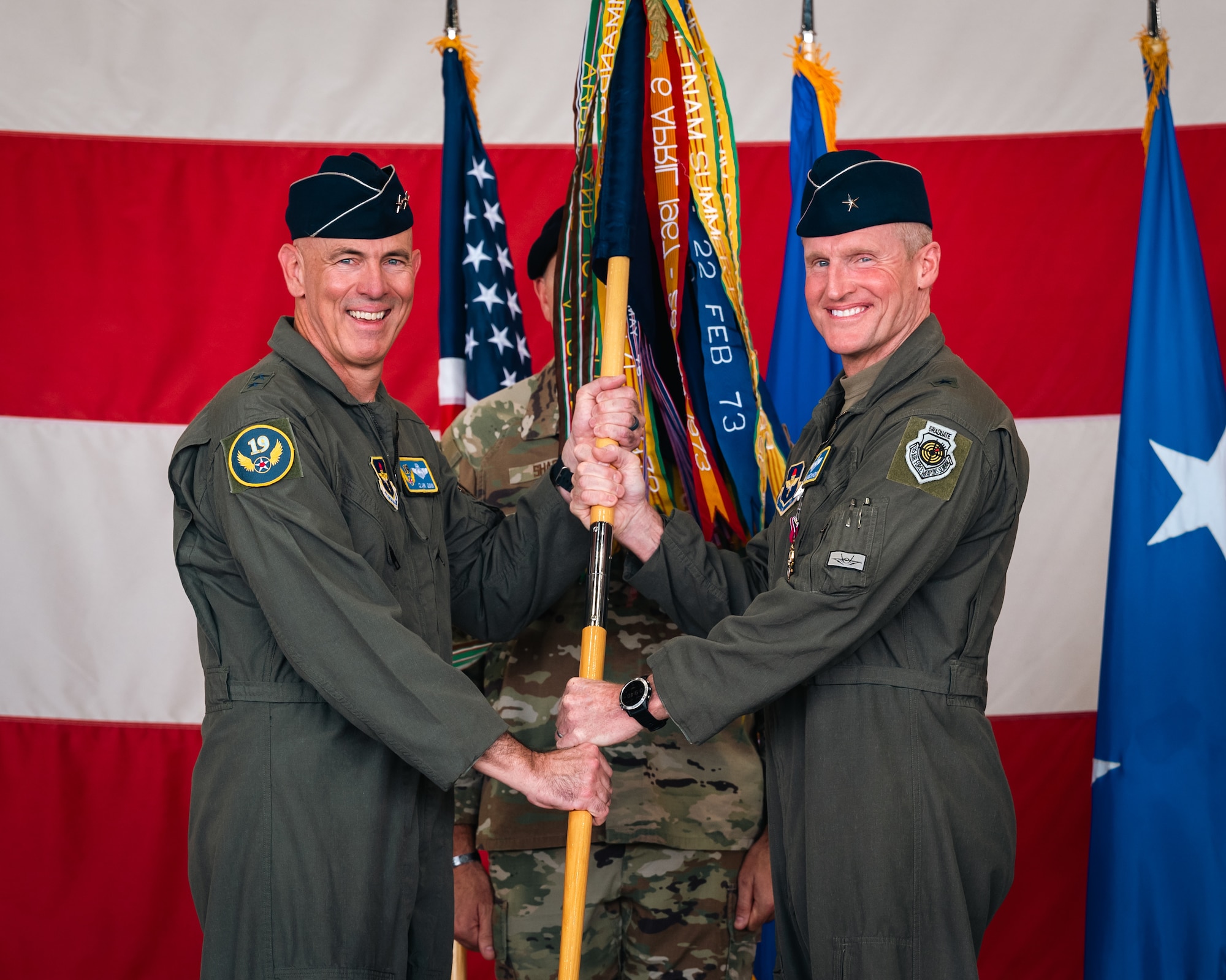 U.S. Air Force Maj. Gen. Clark J. Quinn (left), 19th Air Force commander, receives a guidon from Brig. Gen. Jason Rueschhoff (right), 56th Fighter Wing outgoing commander, before transferring command of the 56th FW to Col. David Berkland at the 56th FW Change of Command ceremony, July 1, 2024, at Luke Air Force Base, Arizona.