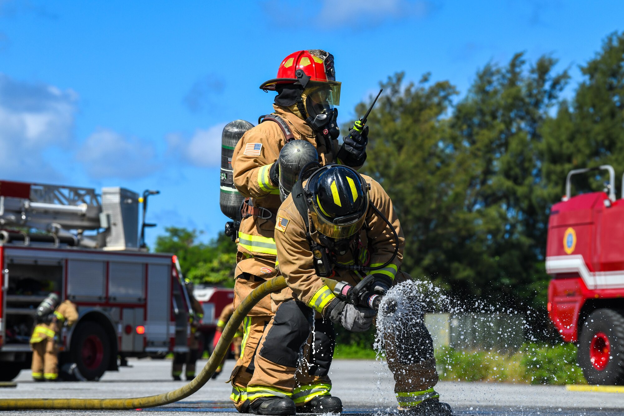 a kadena firefighter checks the hose before the strt of a aircraft fire trainig exersise