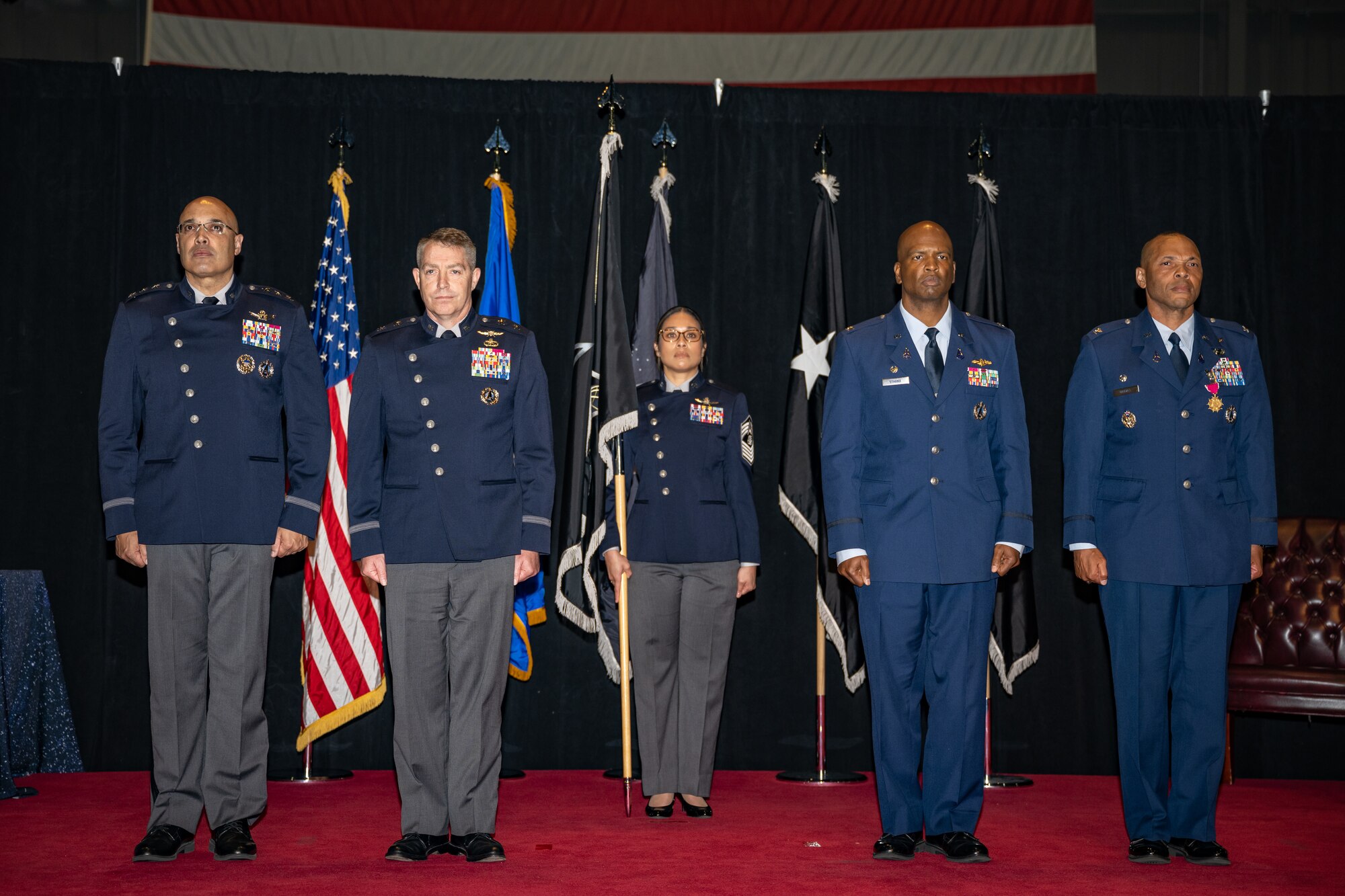 Lt. Gen. David Miller Jr., Space Operations Command commander, Maj. Gen. Gregory Gagnon, deputy chief of Space Operations for Intelligence, Chief Master Sgt. Marivic-Len Olivera, National Space Intelligence Center senior enlisted leader, Col. Marcus Starks, incoming NSIC commander, and Col. Marqus Randall, outgoing NSIC commander, stand at attention during a change of command ceremony at Wright-Patterson Air Force Base, Ohio, June 28, 2024. The historic event was the first NSIC change of command ceremony as well as the activation of the unit as a field operating agency reporting directly to headquarters U.S. Space Force. (U.S. Air Force photo by Daniel Peterson)