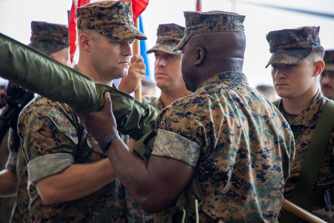 U.S. Marine Corps Lt. Col. Jens Gilbertson, left, from Washington, the commanding officer, and Sgt. Maj. Perry Bessant, from South Carolina, the command senior enlisted leader, both with Marine Light Attack Helicopter Squadron (HMLA) 269, uncase the organizational colors during a reactivation ceremony at Marine Corps Air Station New River, North Carolina, July 1, 2024. The reactivation of HMLA-269 provides 2nd Marine Aircraft Wing and II Marine Expeditionary Force with additional offensive air support, utility support, armed escort, and airborne supporting arms capability. (U.S. Marine Corps photo by Staff Sgt. Theodore Bergan)