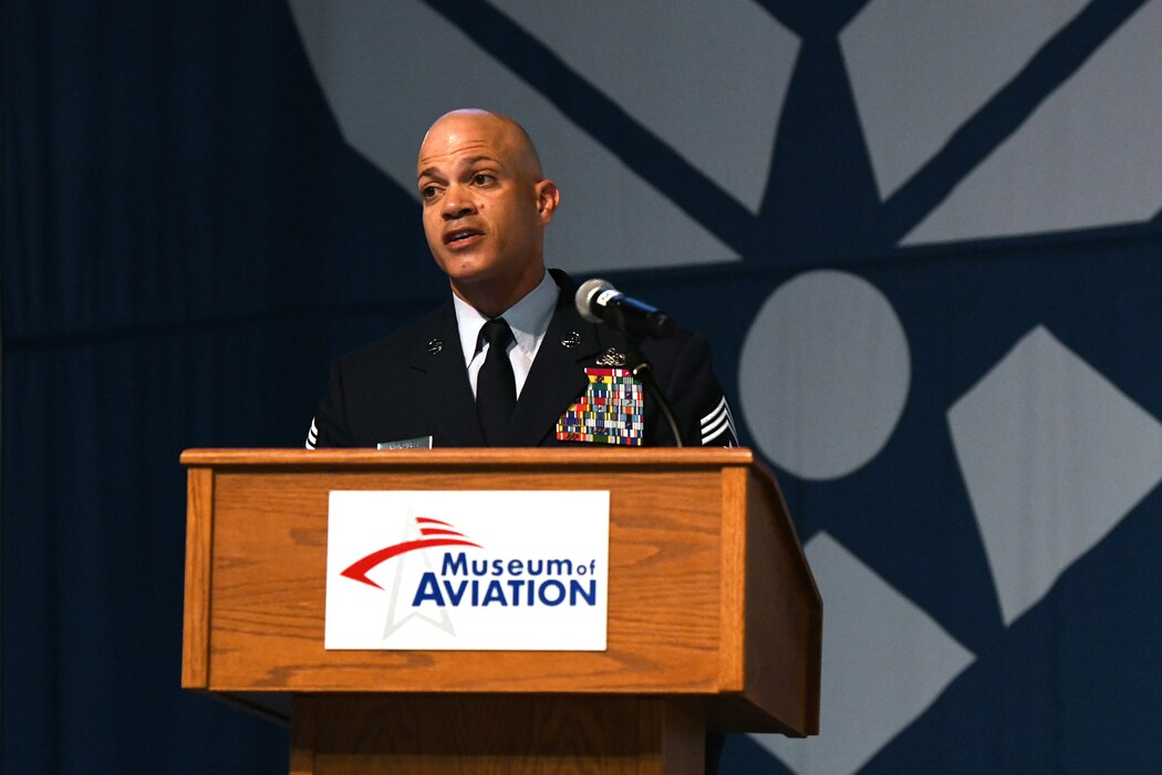 Man in military uniform speaking behind a podium