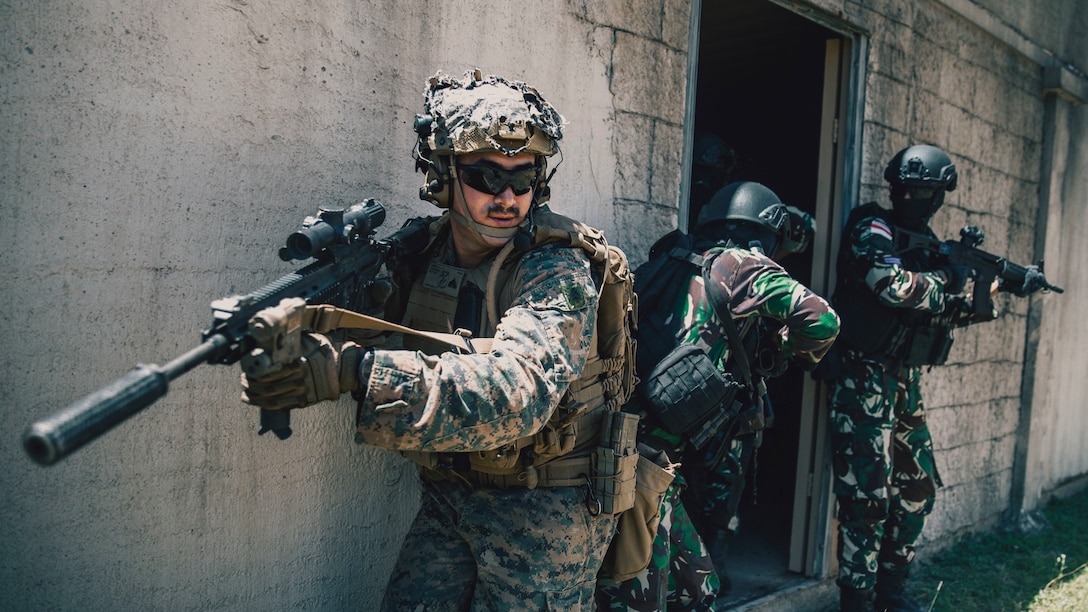 U.S. Marine Corps Cpl. Albert Morelli, a team leader assigned to Battalion Landing Team 1/5, 15th Marine Expeditionary Unit, and a native of Wyoming, holds rear security while Indonesian marines begin clearing a building inside the infantry immersion trainer at Marine Corps Training Area Bellows, Waimanalo, Hawaii, for Exercise Rim of the Pacific 2024, June 29, 2024. The IIT provided immersive scenario-based training to evaluate Marines and partner nations in infantry tactics. Twenty-nine nations, 40 surface ships, three submarines, 14 national land forces, more than 150 aircraft, and 25,000 personnel are participating in and around the Hawaiian Islands, June 27 to Aug. 1. The world’s largest international maritime exercise; RIMPAC provides a unique training opportunity while fostering and sustaining cooperative relationships among participants critical to ensuring the safety of sea lanes and security on the world’s oceans. RIMPAC 2024 is the 29th exercise in the series that began in 1971. (U.S. Marine Corps photo by Cpl. Joseph Helms)