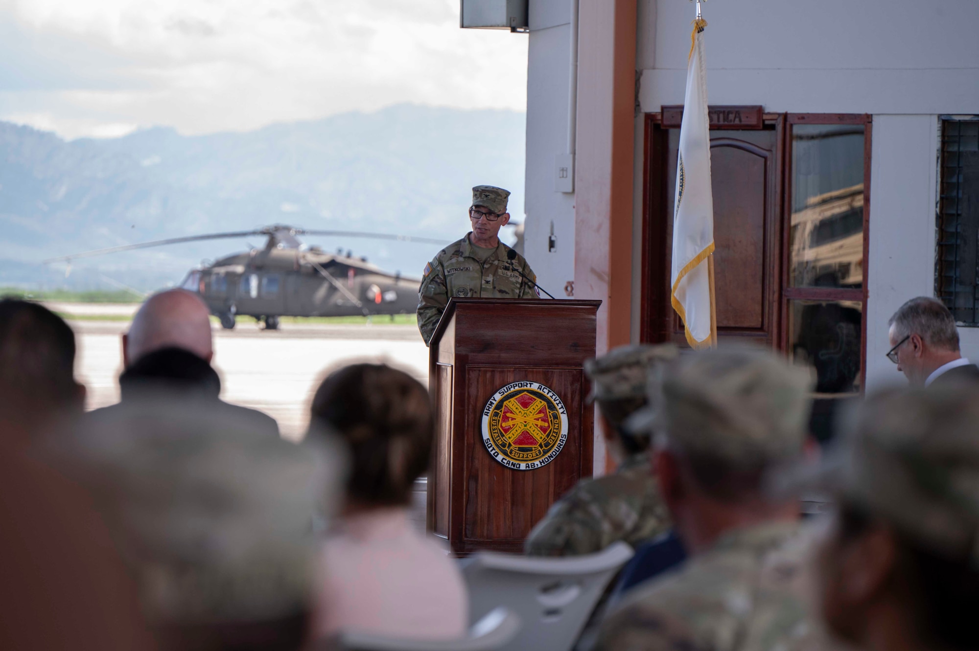 A person standing at a podium speaking to a crowd of people.