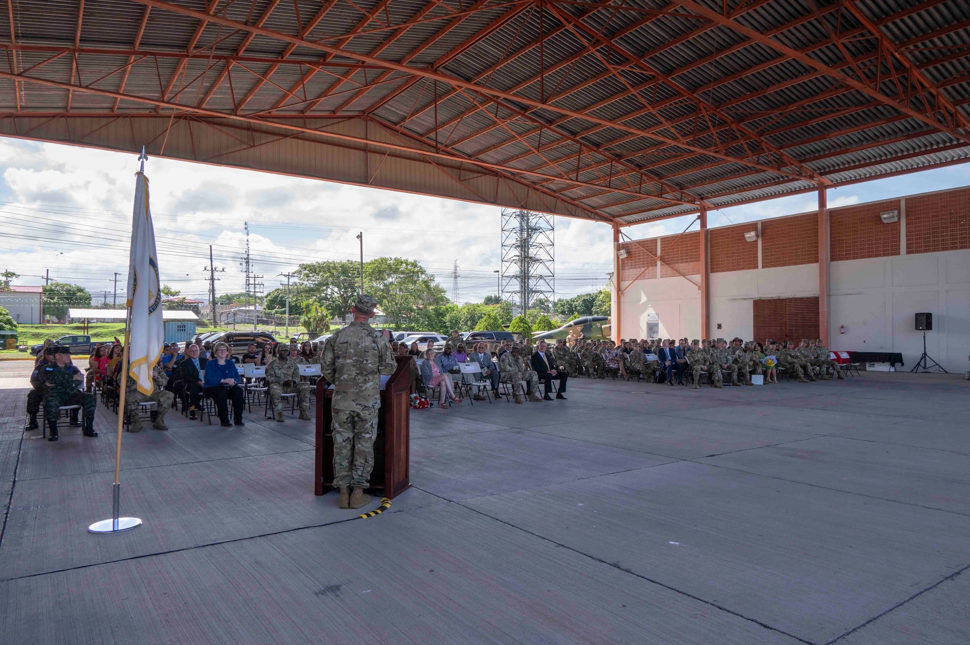 A person standing at a podium speaking to a crowd of people.