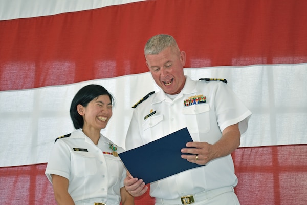 JACKSONVILLE, Fla. (June 28, 2024) – Capt. Craig Malloy, Naval Hospital Jacksonville’s director, makes a joyful connection while presenting Lt. Kelly Le her graduation certificate during the command’s Family Medicine Residency Program graduation ceremony June 28. onboard Naval Air Station Jacksonville. The 11 residents completed two years as residents following a year as an intern.  (U.S. Navy photo by Julie M. Lucas, Naval Hospital Jacksonville/Released).