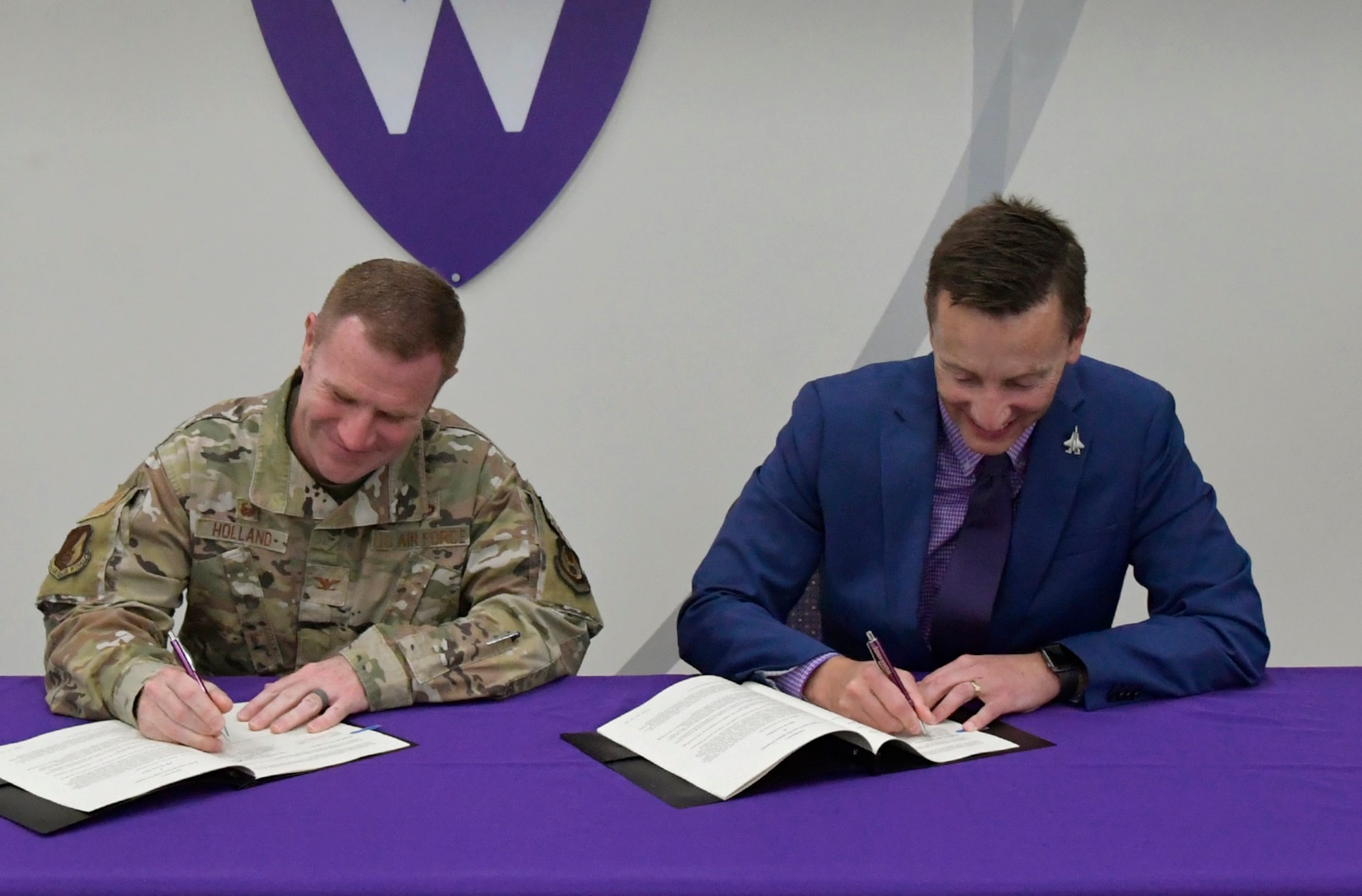 Col. Jeffrey Holland, 75th Air Base Wing commander, and Brad Mortensen, Weber State University president, sign a new partnership partnership agreement expanding education opportunities for military personnel, their families and civilian employees by offering master’s degree programs on the base. (US Air Force photo by Todd Cromar)
