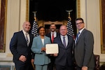 Group photo with all participants looking at the camera and Mallory and Payne holding an award certficate.