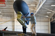 A 9th Maintenance Squadron data link maintainer helps hoist the Pylon Equipment Group (PEG) into the air on Beale Air Force Base, California, April 8, 2024.