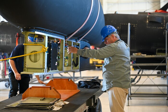 A 9th Maintenance Squadron data link maintainer helps lower the Pylon Equipment Group (PEG) onto a trailer on Beale Air Force Base, California, April 8, 2024.