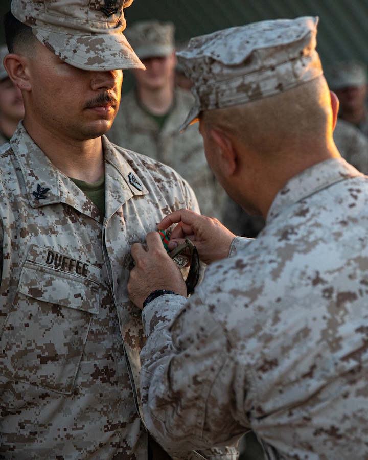 U.S. Navy Petty Officer 2nd Class Grant Duffee, Pennsylvania native, hospital corpsman, 25th Marine Regiment, 4th Marine Division, Marine Forces Reserve, receives a Navy and Marine Corps Achievement Medal during Integrated Training Exercise 4-24 at Marine Air-Ground Combat Center Twentynine Palms, California, June 26, 2024. The NAM is awarded to U.S. service members that demonstrate superior performance and sustained meritorious service in their duties. ITX enables the Reserve Component to simulate a mobilization and deploy its forces in preparation for potential future deployments in the event of a contingency or crisis. (U.S. Marine Corps photo by Lance Cpl. Orion Stpierre)