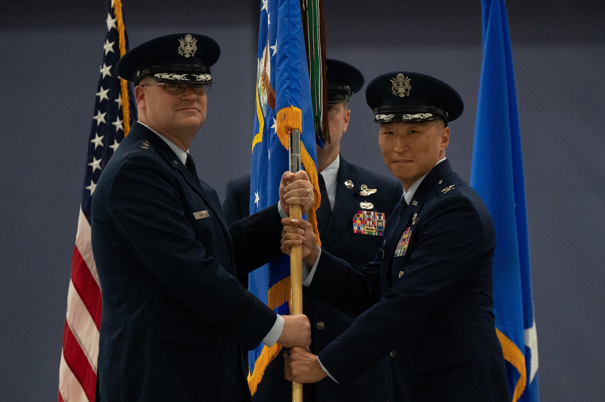 U.S. Air Force Maj. Gen. Daniel A. DeVoe, Air Force District of Washington commander, passes the guidon to U.S. Air Force Col. Jun S. Oh as he assumes command of the 316th Wing