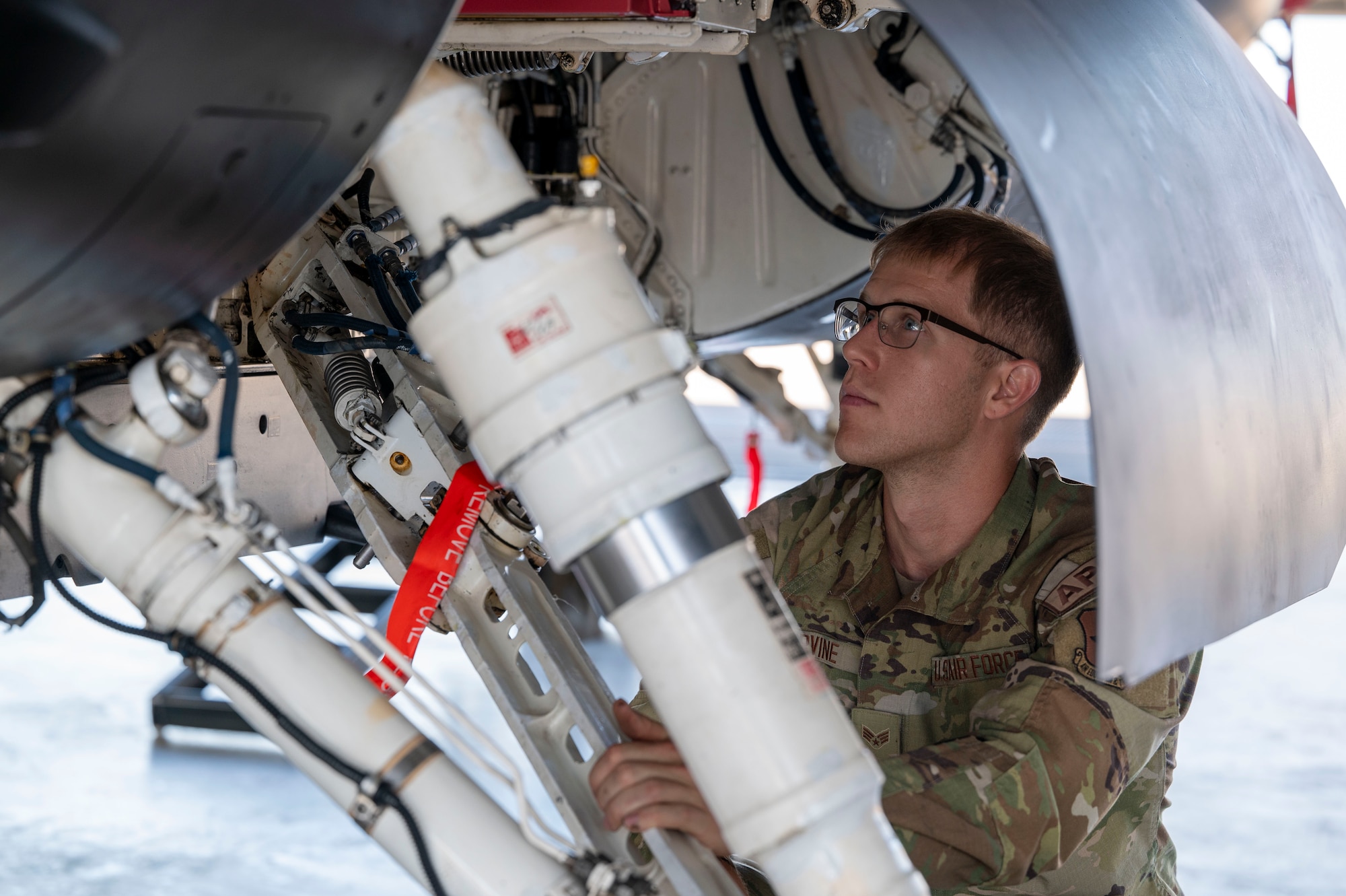 U.S. Air Force Senior Airman Connor Irvine, 8th Aircraft Maintenance Unit dedicated crew chief, performs a pre-flight inspection on an F-16 Viper at Holloman Air Force Base, New Mexico, June 5, 2024. The 8th Fighter Squadron unveiled its new flagship, which is painted with a matte black color scheme that draws inspiration from the legendary F-117 Nighthawk stealth aircraft. (U.S. Air Force photo by Airman 1st Class Michelle Ferrari)