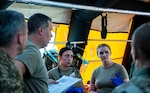 Members of the Colorado National Guard and their State Partnership Program partner, the Republic of Slovenia, treat a patient in their medical tent, part of Colorado’s Chemical, Biological, Radiological and Nuclear Enhanced Response Force Package, during the Vigorous Warrior and Clean Care medical exercises, May 7, 2024, at Bakonykúti Training Area, Hungary. The CERFP is a domestic operations capability in the U.S., deployed to showcase the capability of doing mass decontamination in a battlefield setting while integrating emergent medical treatment. (U.S. Air National Guard photo by Airman 1st Class Eliana Raspet)