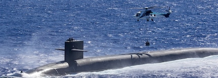 An AS-332 Super Puma assigned to the Lewis and Clark-class dry cargo ship  USNS Cesar Chavez (T-AKE 14) delivers supplies to the Ohio-class ballistic missile submarine USS Louisiana (SSBN 743) during a vertical replenishment at sea.