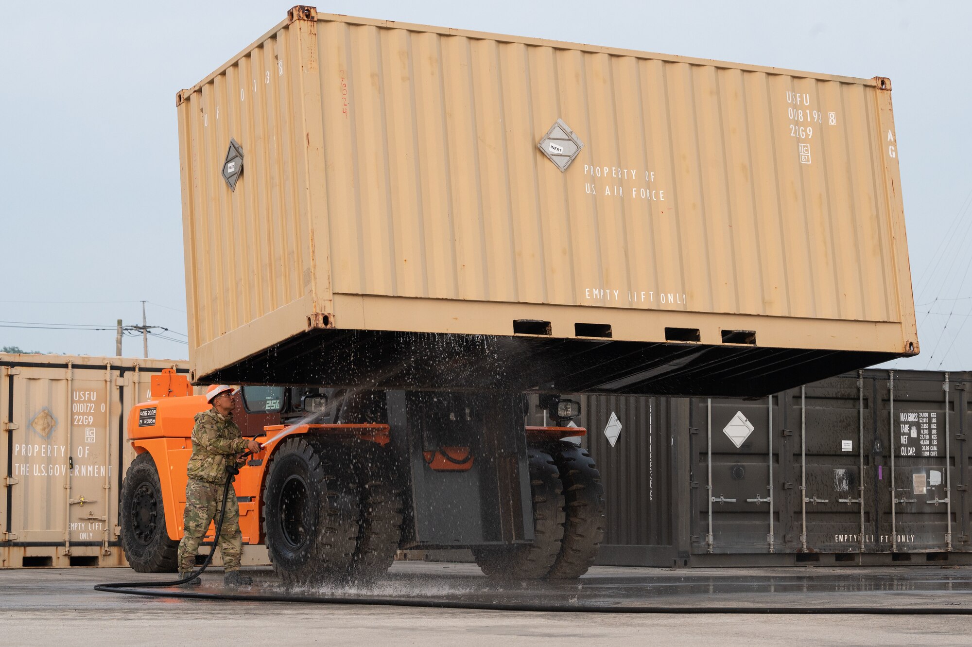 Senior Airman Caleb Salgado, 8th Civil Engineer Squadron pavements and heavy equipment journeyman, washes an intermodal container during a munitions retrograde.