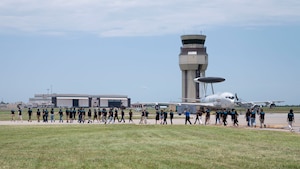 Premier College Intern Program members walk on the flightline across from an E-3 Sentry aircraft June 26, 2024, at Tinker Air Force Base, Oklahoma.