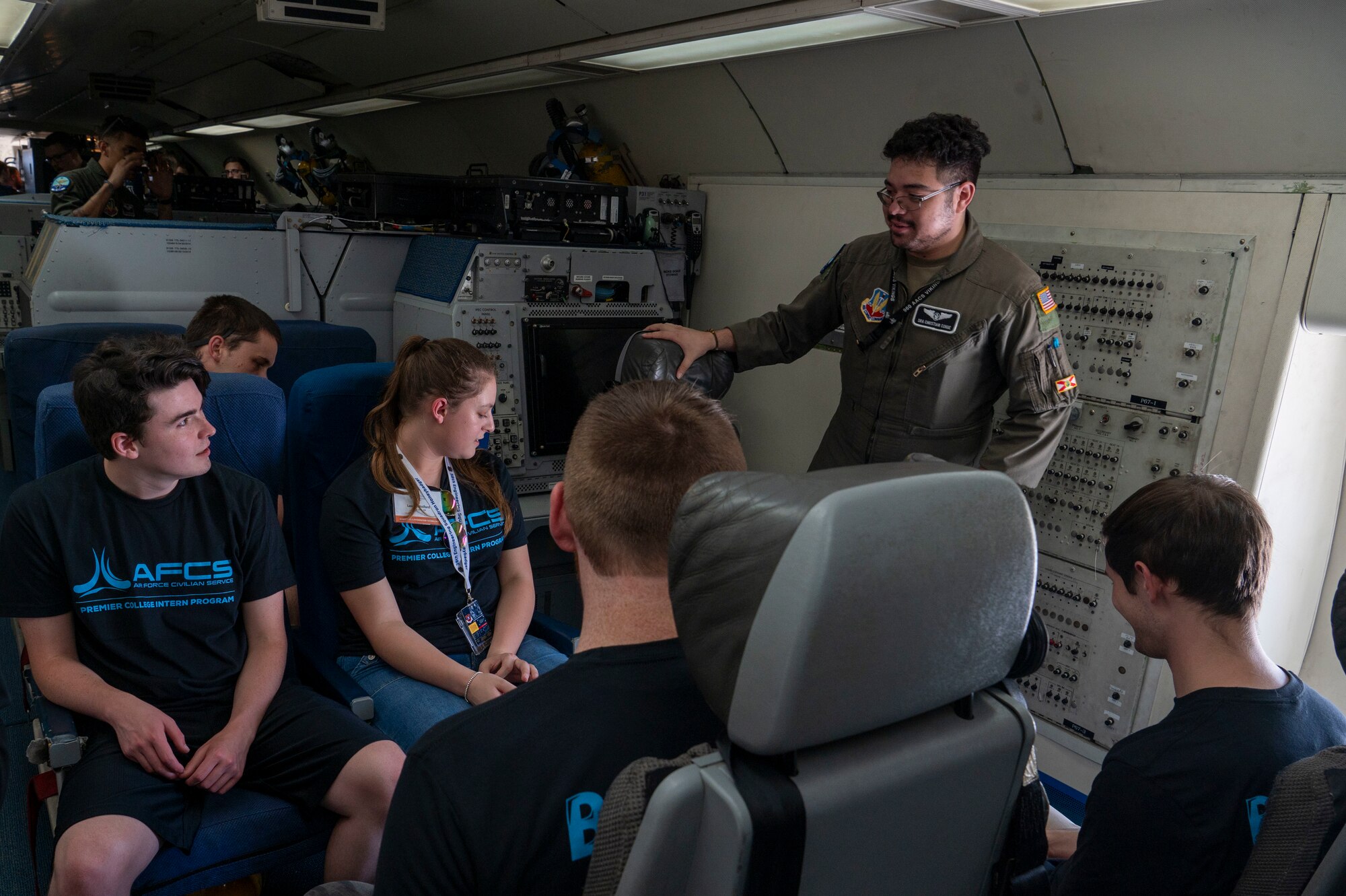 Senior Airman Christian Conde, 960th Airborne Air Control Squadron mission systems operator explains his duties to Premiere College Intern Program members, June 26, at Tinker Air Force Base, Oklahoma.
