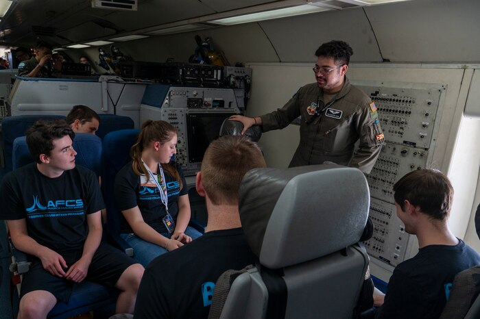 Senior Airman Christian Conde, 960th Airborne Air Control Squadron mission systems operator explains his duties to Premiere College Intern Program members, June 26, at Tinker Air Force Base, Oklahoma.
