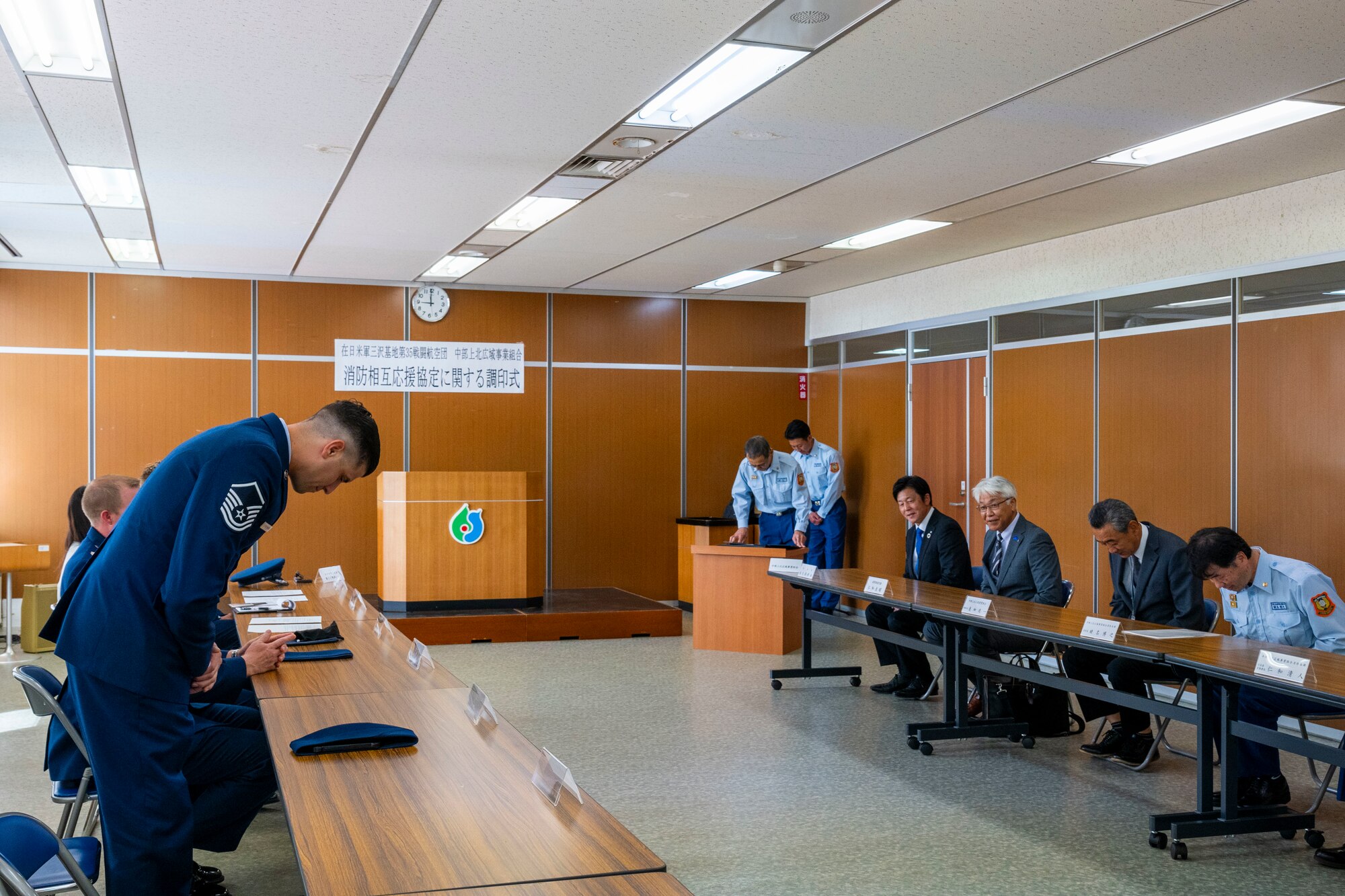 U.S. Air Force Master Sgt. Aaron Strayhorn, left, 35th Civil Engineer Squadron deputy fire chief, bows in greeting to Tohoku Town officials during a Memorandum of Understanding International (MoUI) during the Fire Protection Agreement ceremony at Tohoku Town, Japan, July 1, 2024.