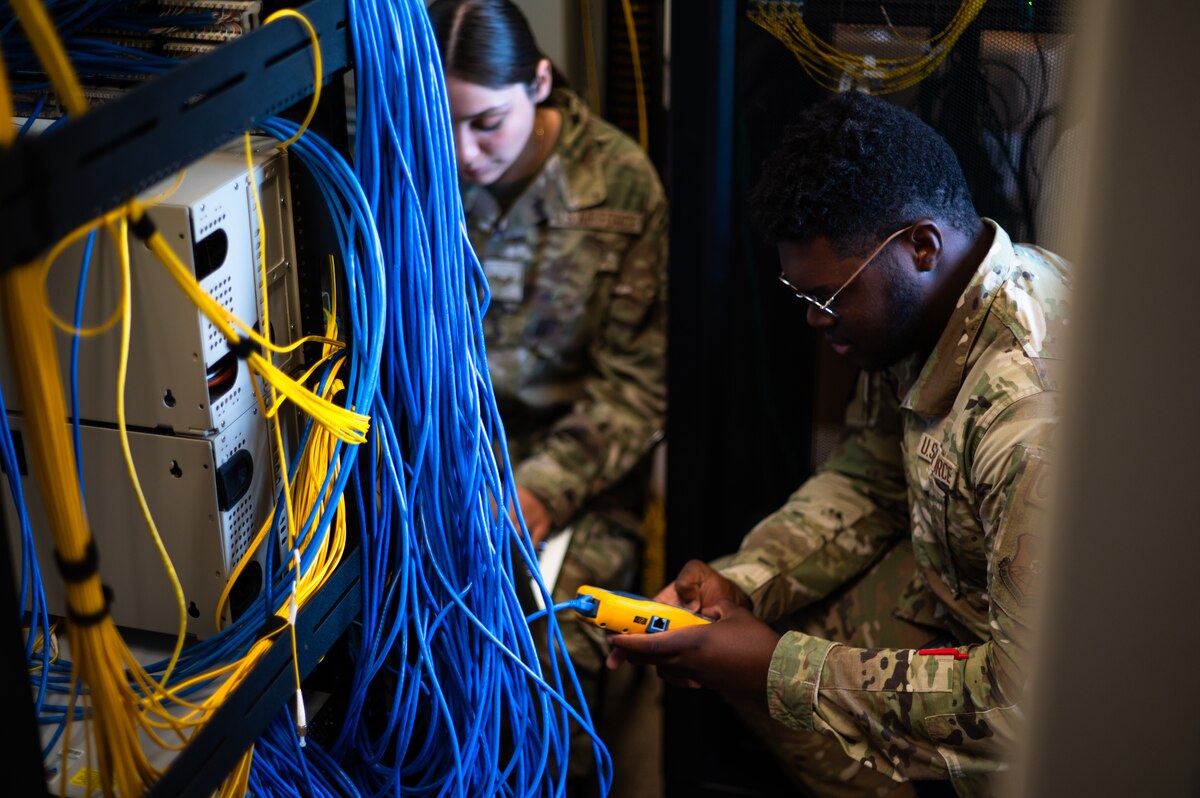 U.S. Air Force Senior Airman Isabella Romo, left, and Airman 1st Class Cameron Ganaway, 7th Communication Squadron cyber defense operations technicians, look over equipment at Dyess Air Force Base, Texas, June 26, 2024. The 7th CS dedicated over six months to planning and three months implementing a base-wide network improvement. (U.S. Air Force photo by Airman 1st Class Jade M. Caldwell)